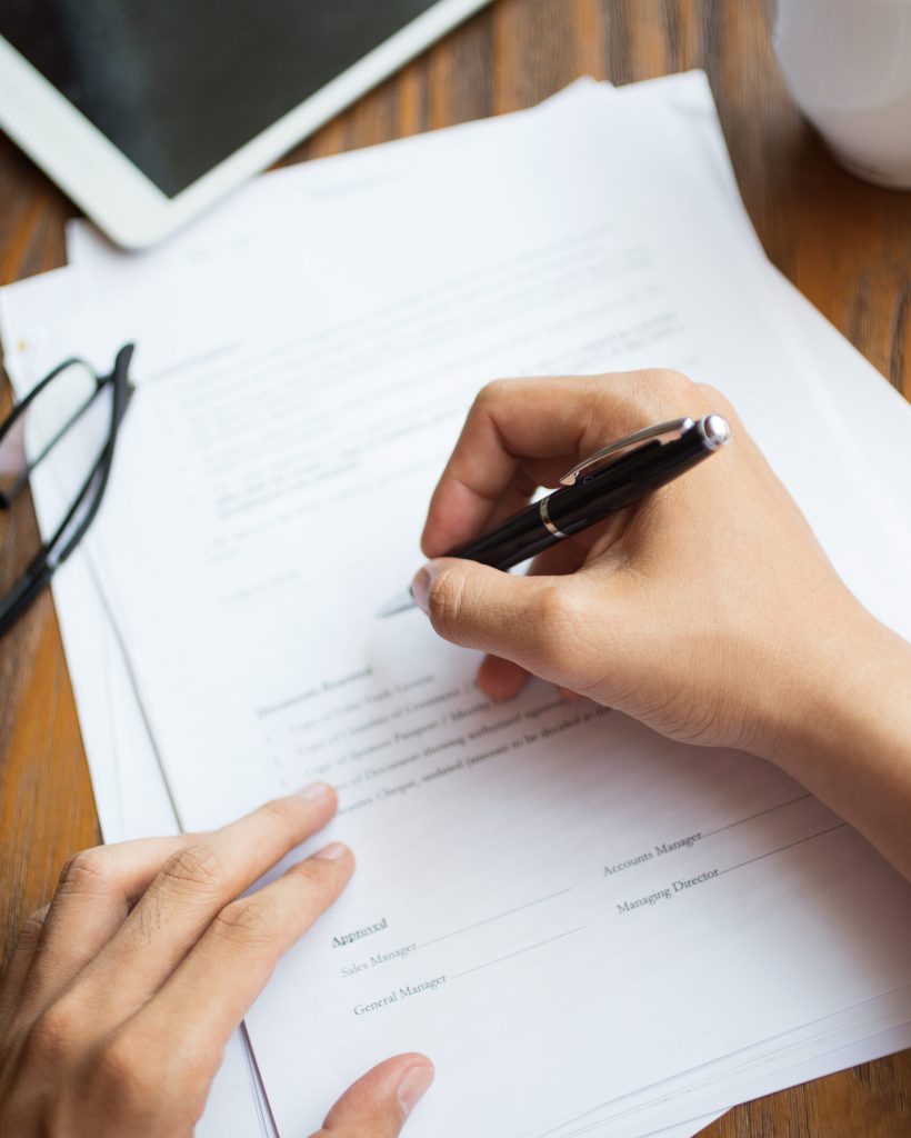 Unrecognizable man filling application form. Businessman checking papers. He signing document. Manager working with report. Financial report concept
